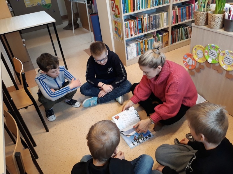 Uczniowie klasy trzeciej słuchają czytanej przez nauczyciela książki