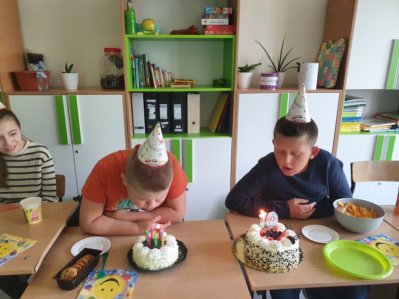 Chłopcy dmuchają świeczki na tortachjpg